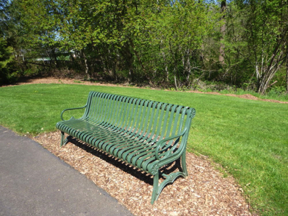 One of many benches in bark chips off the paved perennial trails